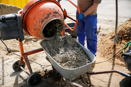 Constriction worker making concrete in an orange mixer