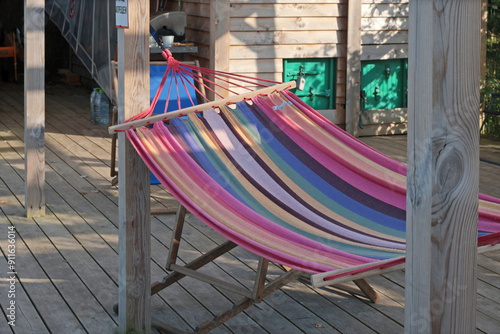 Hammock on wooden terrace of old barn near sea at beach. Nature and recreation. Meditation and relaxation. Background for text and design. photo