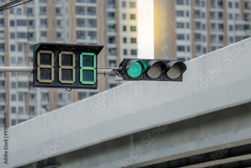 close up of red light showing 8 seconds time left for green light 2 condominium buildings in the back photo