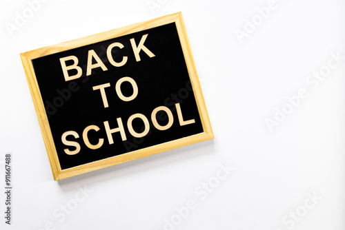 Black school board with "Back to School" inscription made of wooden letters. Top view. For backgrounds and presentations