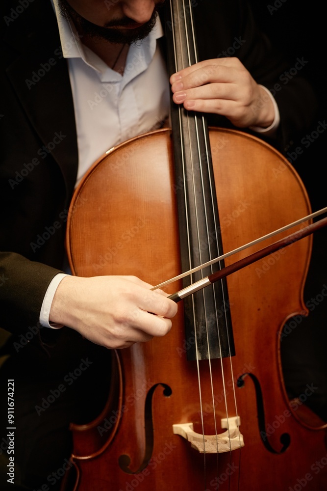 Vertical cropped shot of unrecognizable male classical music artist playing cello with bow Vertical cropped shot of unrecognizable male classical music artist playing cello with bow