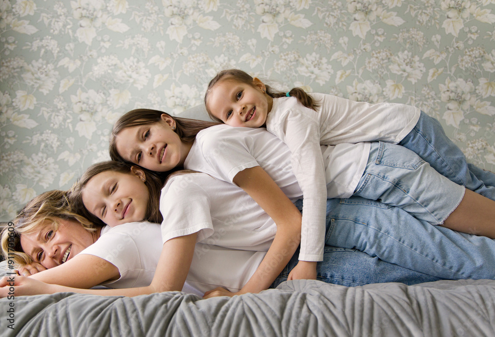 Happy Family of Four Relaxing on Bed in Home Happy Family of Four Relaxing on Bed in Home
