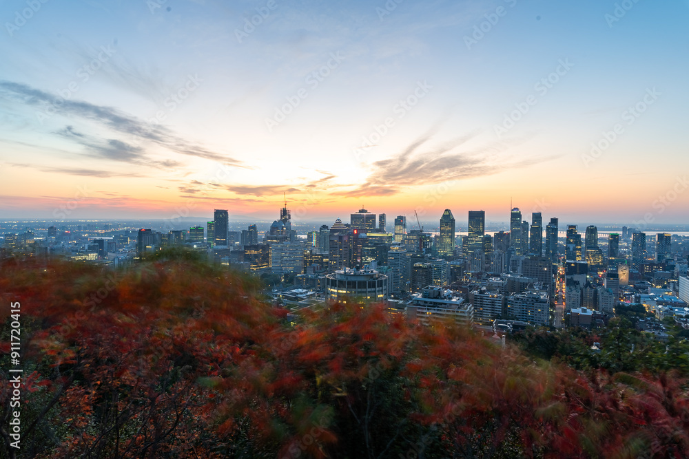 Naklejka premium Montreal sunrise from Mont Royal Kondiaronk Belvedere with colorful leaves. Panoramic skyline view of downtown Montreal from top view at sunrise in Canada