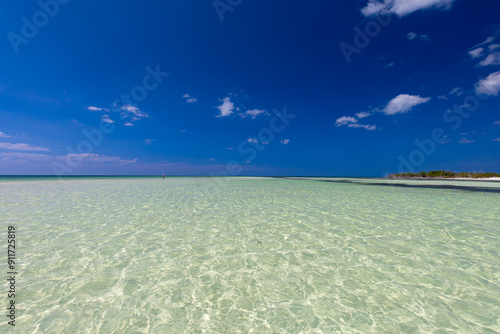 Repos et vacances sur une belle plage de sable avec une vue exotique sur l'océan contre un ciel bleu avec des nuages ​​blancs, Cuba, fond pour le design, papier peint