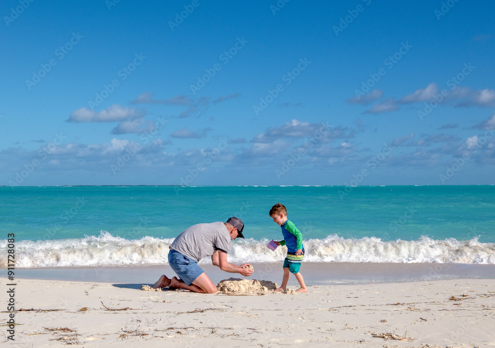 Family vacation in the Bahamas - Father & Son Make Sandcastle on Beach Family vacation in the Bahamas - Father & Son Make Sandcastle on Beach