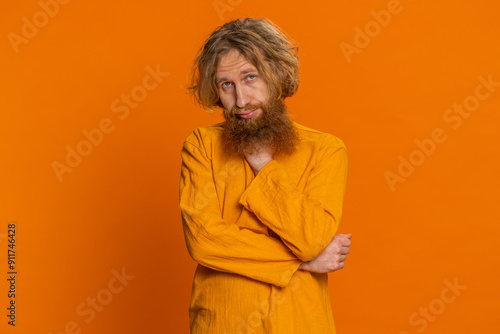 Caucasian man tired bored indifferent expression, exhausted of tedious story, not interested in communication talk, displeasure, uninteresting. Redhead young guy isolated on orange background photo