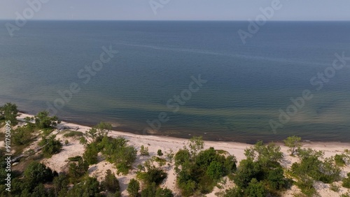 Beach front shoreline on Lake Ontario coast peaceful water blue sky morning light conservation nature preserve at Black Pond Beach in New York 