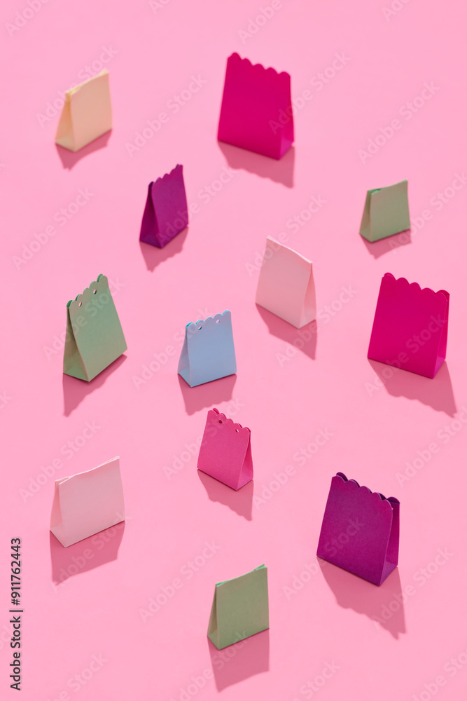 Colorful paper gift bags arranged on pink background Colorful paper gift bags arranged on pink background