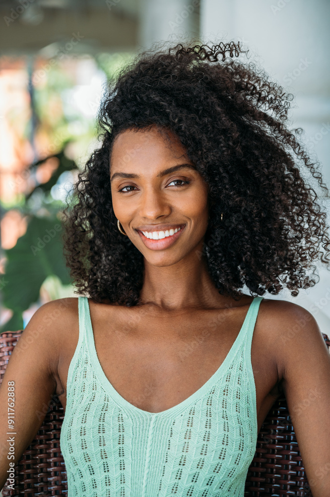 Radiant young woman with curly hair smiling outdoors Radiant young woman with curly hair smiling outdoors