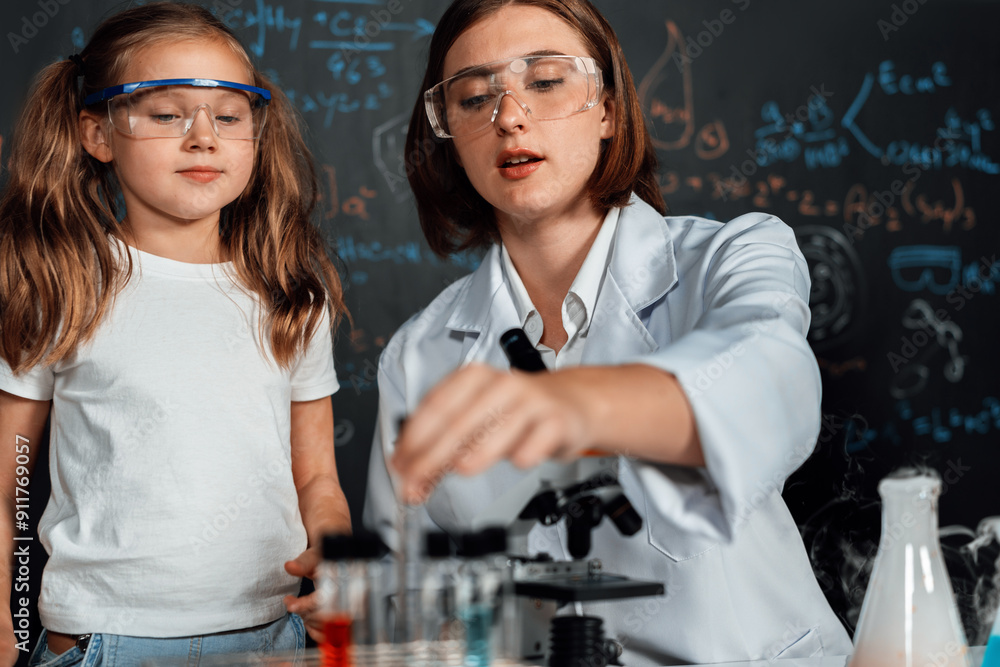 Teacher in support and watch student in laboratory they wear safety glasses, stand and experiment about science of chemistry in STEM class. Student funny do experiment with liquid in tube. Erudition. Teacher in support and watch student in laboratory they wear safety glasses, stand and experiment about science of chemistry in STEM class. Student funny do experiment with liquid in tube. Erudition.