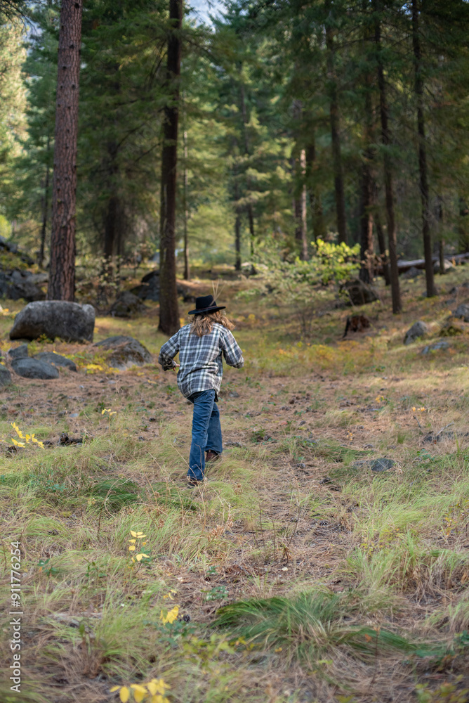 young man in flannel shirt and jeans, hiking in autumn forest young man in flannel shirt and jeans, hiking in autumn forest