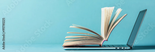 Open Book Emerging From Laptop on Blue Background photo