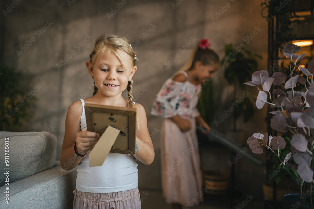 Young sweet girls sisters do chores clean and dust shelves and frame Young sweet girls sisters do chores clean and dust shelves and frame