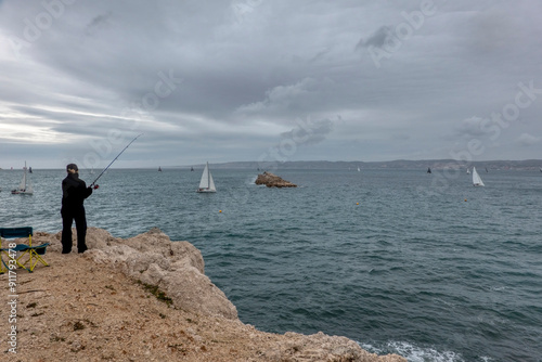 Anonymous woman fishing off the coast of Marseille, France