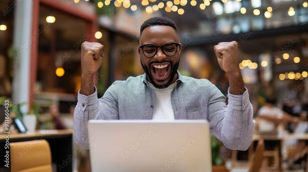 A business owner celebrating a sale while looking at their laptop. A business owner celebrating a sale while looking at their laptop.