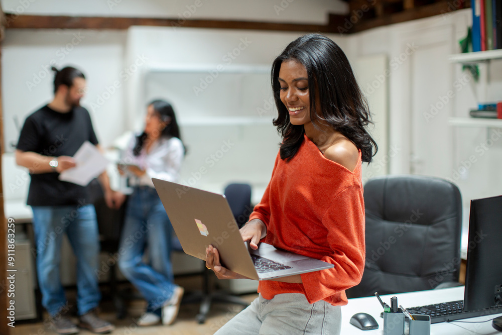 smiling woman in office standing with laptop smiling woman in office standing with laptop