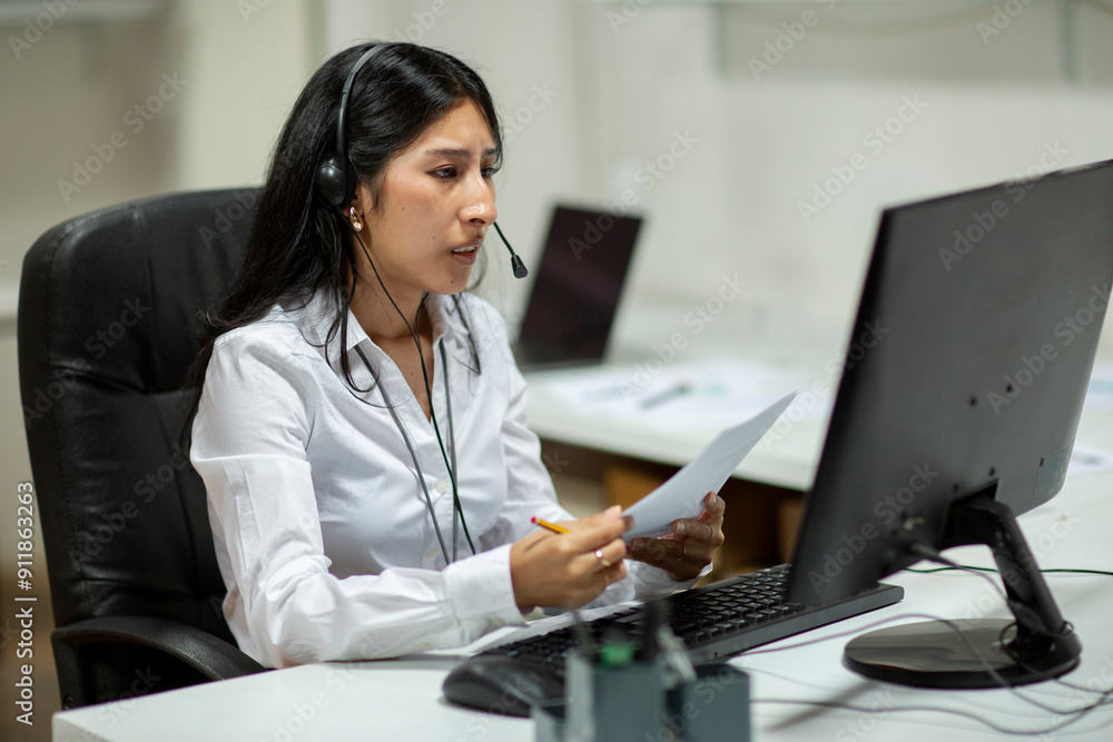 Woman with headset in office in front of computer Woman with headset in office in front of computer