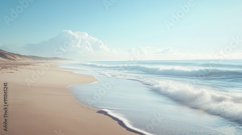 Panoramic view of a sandy beach with gentle sea waves rolling onto the shore, creating a serene landscape