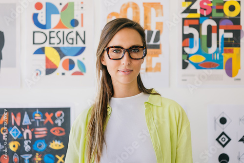 Young woman in glasses against colorful design posters photo