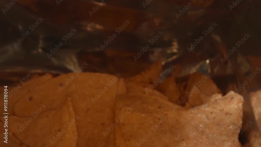 Close up of snacks scattered and contained in a package. Macro of snack placed with moving camera. Studio macro shot of potato chip with seasoning powder. Copy space for design and print. Pabulum. Close up of snacks scattered and contained in a package. Macro of snack placed with moving camera. Studio macro shot of potato chip with seasoning powder. Copy space for design and print. Pabulum.