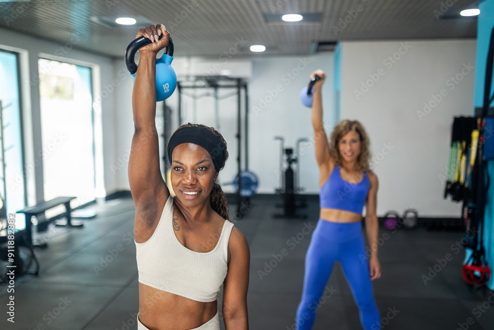 Multiracial women lifting weights in a gym Multiracial women lifting weights in a gym