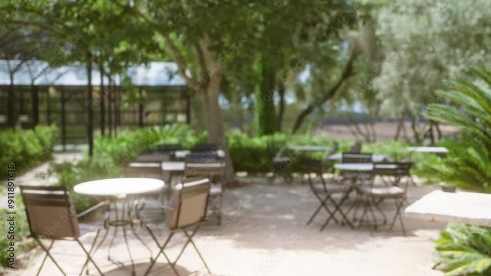 Blurred outdoor scene of a cafe or restaurant terrace in mallorca featuring numerous empty tables and chairs under a canopy of trees and greenery Blurred outdoor scene of a cafe or restaurant terrace in mallorca featuring numerous empty tables and chairs under a canopy of trees and greenery