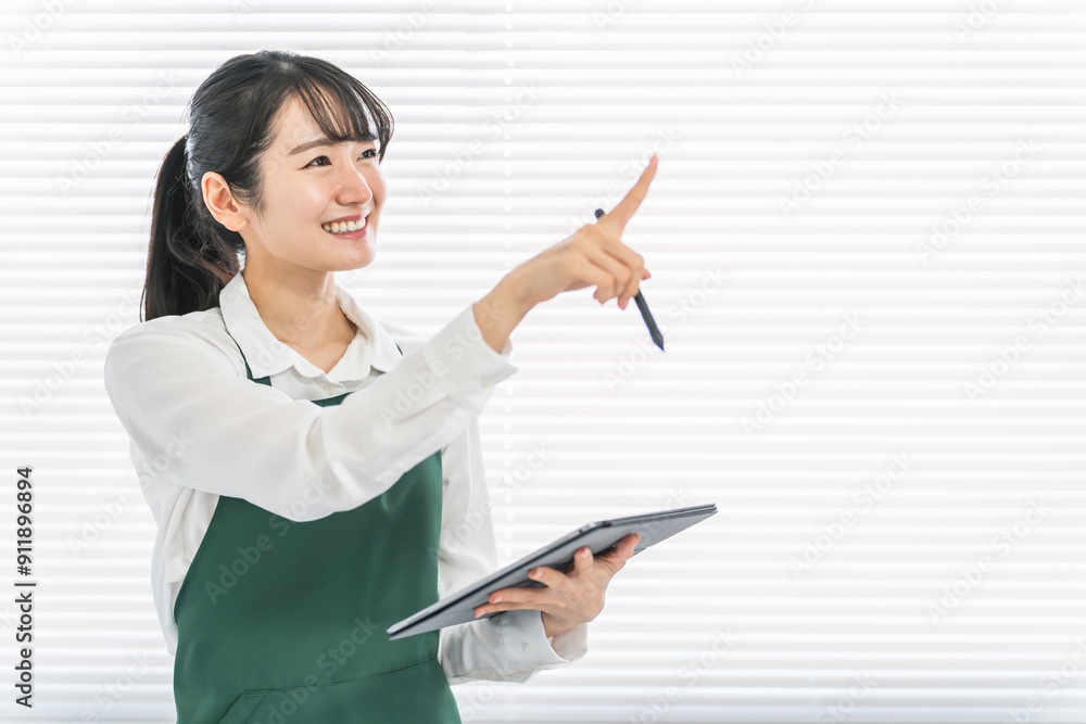 コンビニ・スーパーでタブレット端末を使って在庫管理をする店員・バイトの女性

