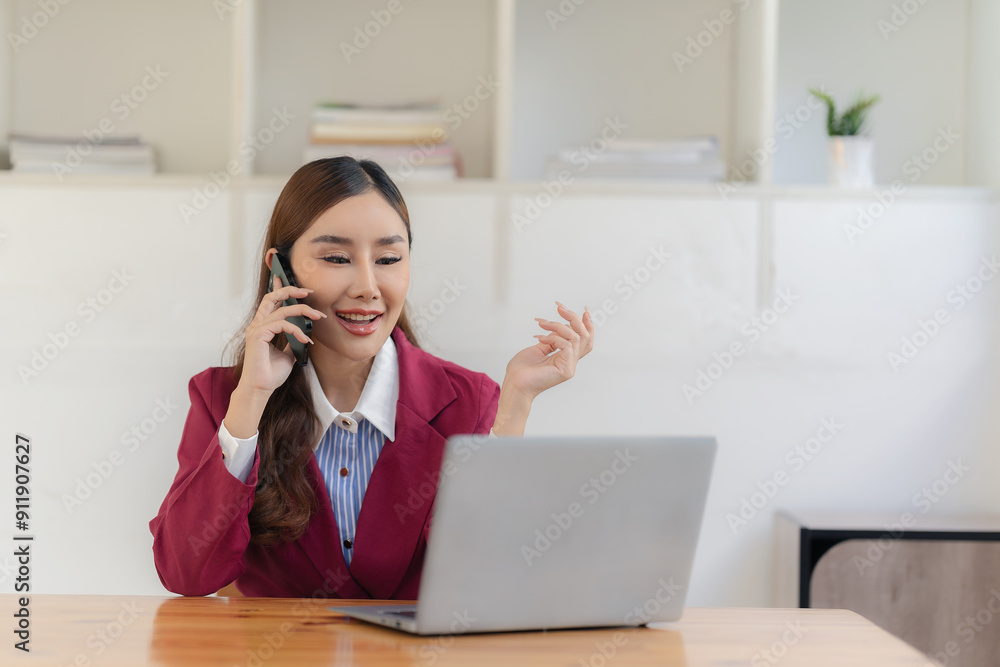 Business women in the office use smartphones to send online messages and talk with customers on the phone and use laptops to conduct financial business online, discuss and contact customers. Business women in the office use smartphones to send online messages and talk with customers on the phone and use laptops to conduct financial business online, discuss and contact customers.