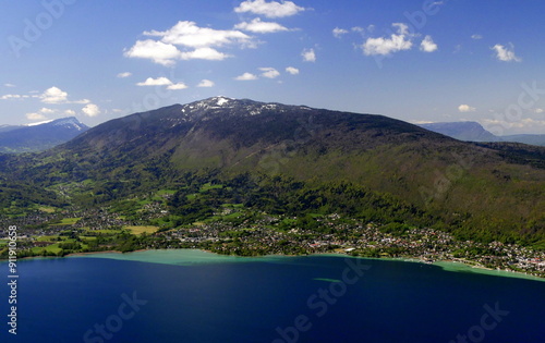 Semnoz montain peak covered in snow seen from mount Baron on top of Annecy lake in spring