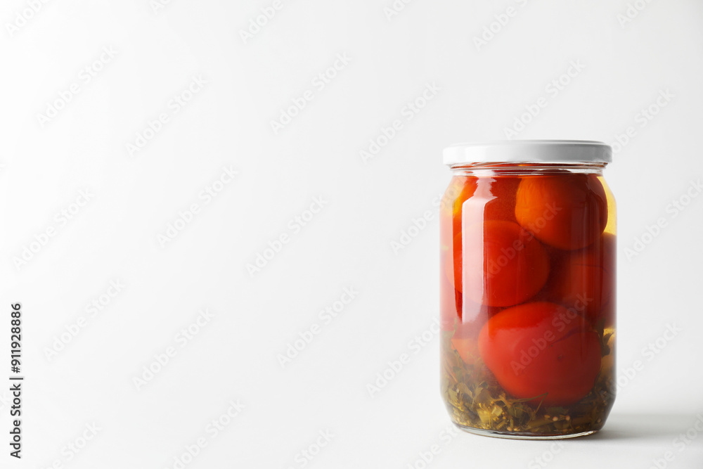 Tasty pickled tomatoes in jar on light grey background. Space for text Tasty pickled tomatoes in jar on light grey background. Space for text
