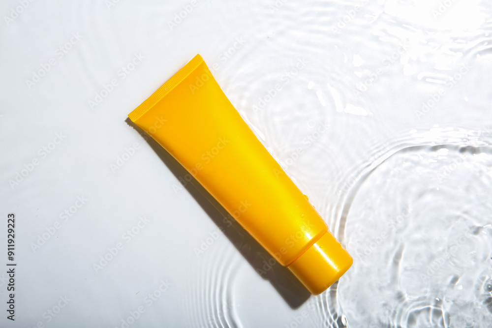Cosmetic product. Tube with cream in water on light background, top view Cosmetic product. Tube with cream in water on light background, top view