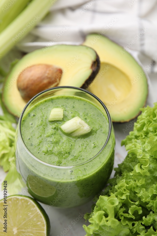 Tasty green smoothie in glass and products on white table, closeup Tasty green smoothie in glass and products on white table, closeup
