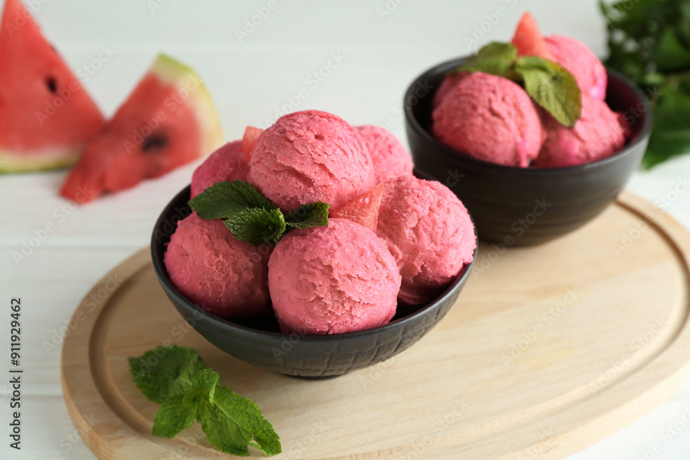 Scoops of tasty watermelon sorbet in bowls and mint on white wooden table Scoops of tasty watermelon sorbet in bowls and mint on white wooden table