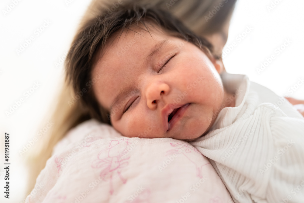 Venezuelan newborn baby girl sleeping peacefully on mother's shoulder
