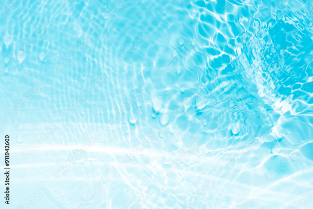 Obraz premium Blue water with ripples on the surface. Defocus blurred transparent blue colored clear calm water surface texture with splashes and bubbles. Water waves with shining pattern texture background.