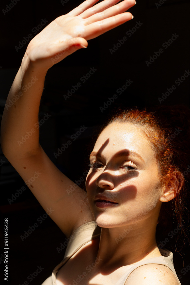 Woman in sunlight protecting her face from the sun with her hand Woman in sunlight protecting her face from the sun with her hand