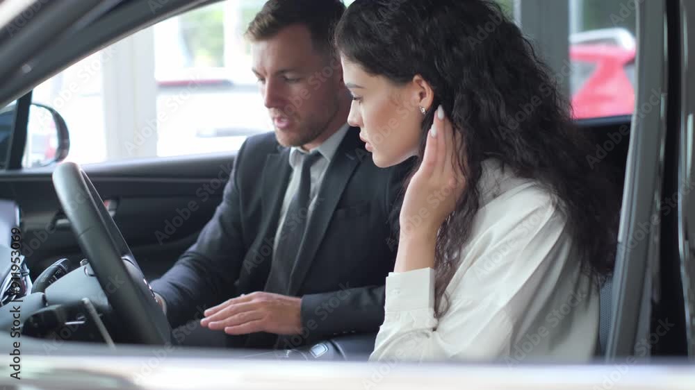 a man and a woman are sitting in a car talking on a cell phone a man and a woman are sitting in a car talking on a cell phone