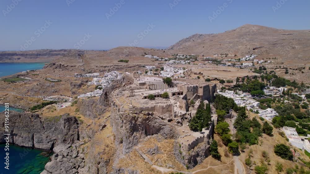 Aerial view of Lindos’ Acropolis perched atop a peak with beautiful views of Rhodes, Greece. Aerial view of Lindos’ Acropolis perched atop a peak with beautiful views of Rhodes, Greece.