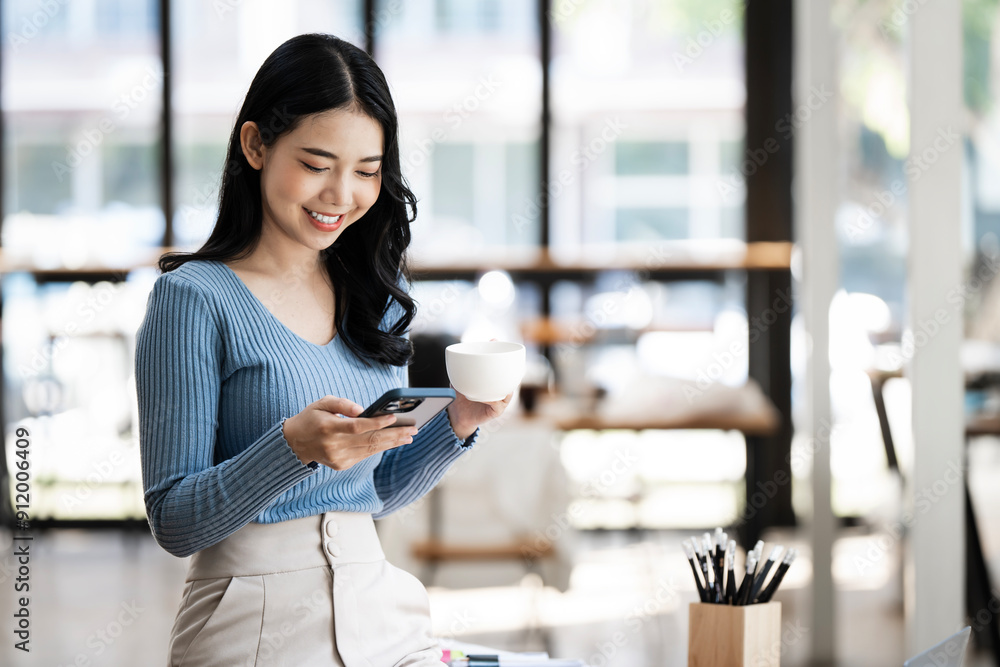 Happy professional woman sits at her office desk and using mobile phone. Happy professional woman sits at her office desk and using mobile phone.