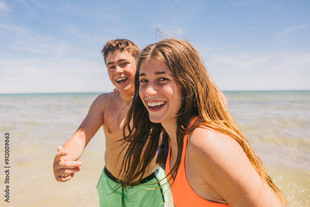 Teenagers enjoying a sunny day at the beach, smiling and laughing Teenagers enjoying a sunny day at the beach, smiling and laughing