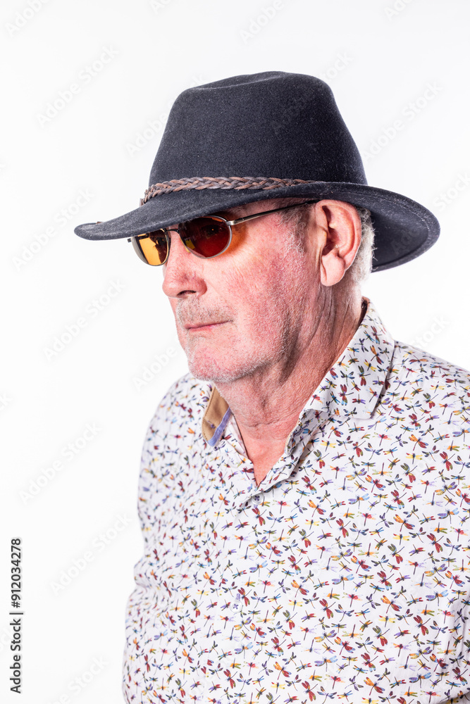 A stylish older gentleman exudes confidence in a chic hat and trendy sunglasses, making a bold outdoor statement A stylish older gentleman exudes confidence in a chic hat and trendy sunglasses, making a bold outdoor statement