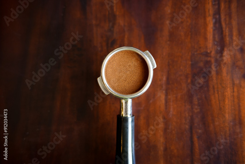 Top view of ground coffee in porta filter or portable coffee filter handle and ground coffee for a coffee making machine