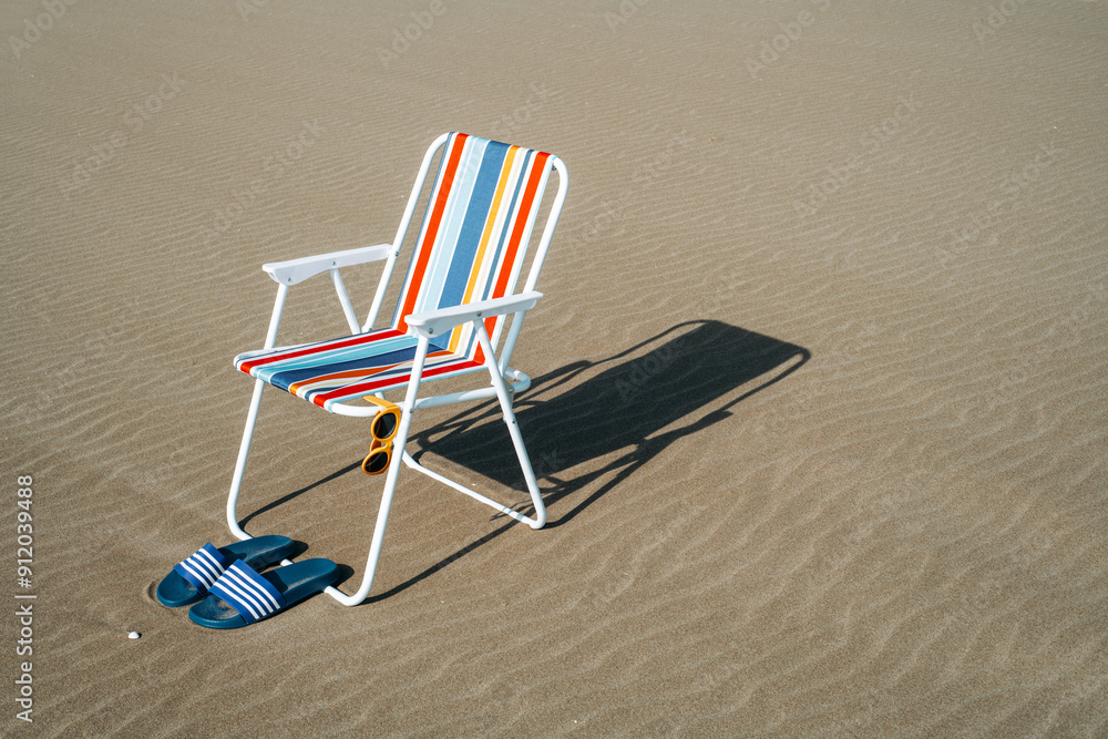 sandals, sunglasses and folding chair on the sand sandals, sunglasses and folding chair on the sand