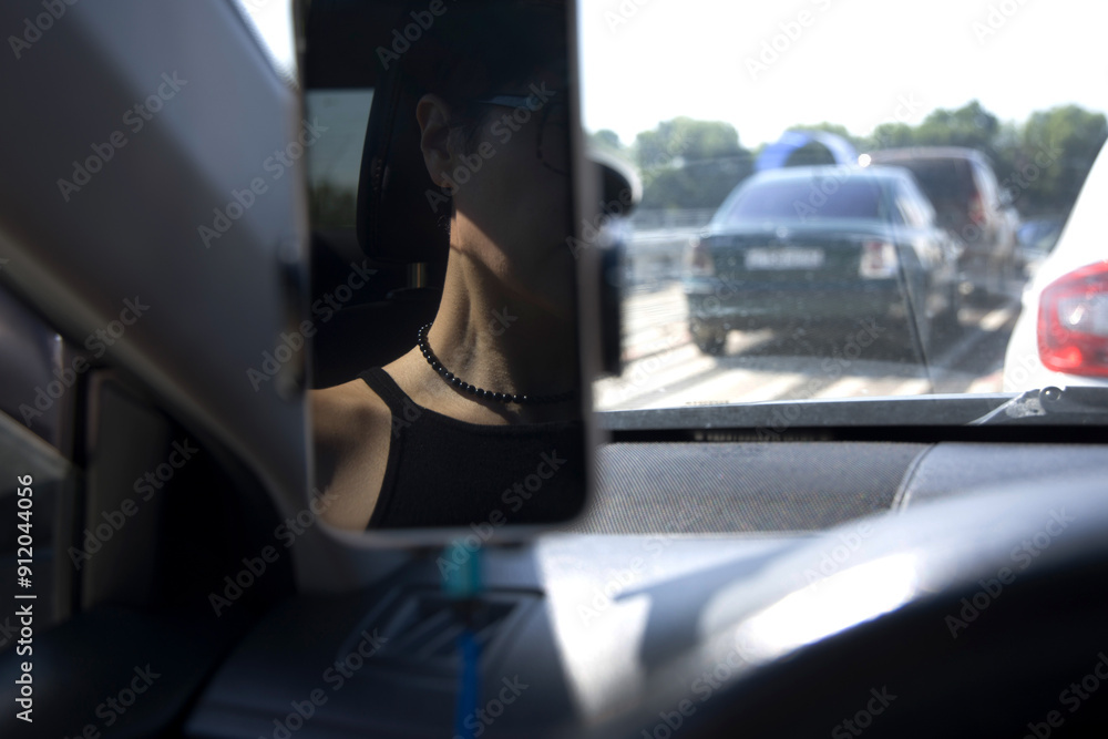 Reflection of Person in Black Tank Top Driving a Car Reflection of Person in Black Tank Top Driving a Car