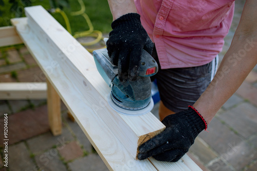 a man processes wood in the yard photo