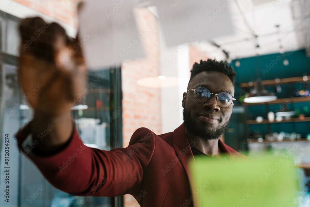 Man Placing Sticky Notes on Glass Man Placing Sticky Notes on Glass
