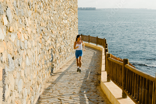 A young lady jogs along a boardwalk early in the morning