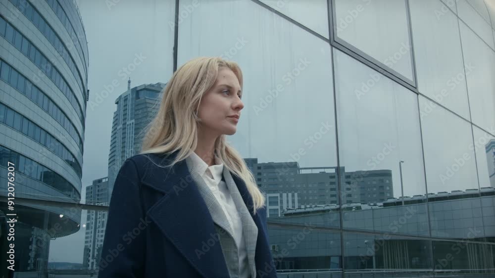 A businesswoman with blonde hair stands outside a glass building in London, her confident stance and professional attire making a striking impression against the sleek, modern architecture A businesswoman with blonde hair stands outside a glass building in London, her confident stance and professional attire making a striking impression against the sleek, modern architecture