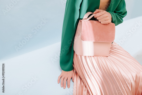 Stylish Pink Handbag Held by Woman in Elegant Outfit