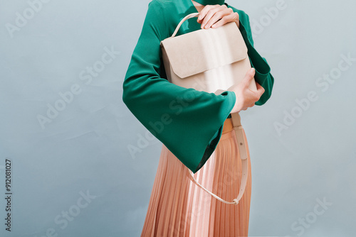 Elegant Woman Holding Stylish Beige Handbag